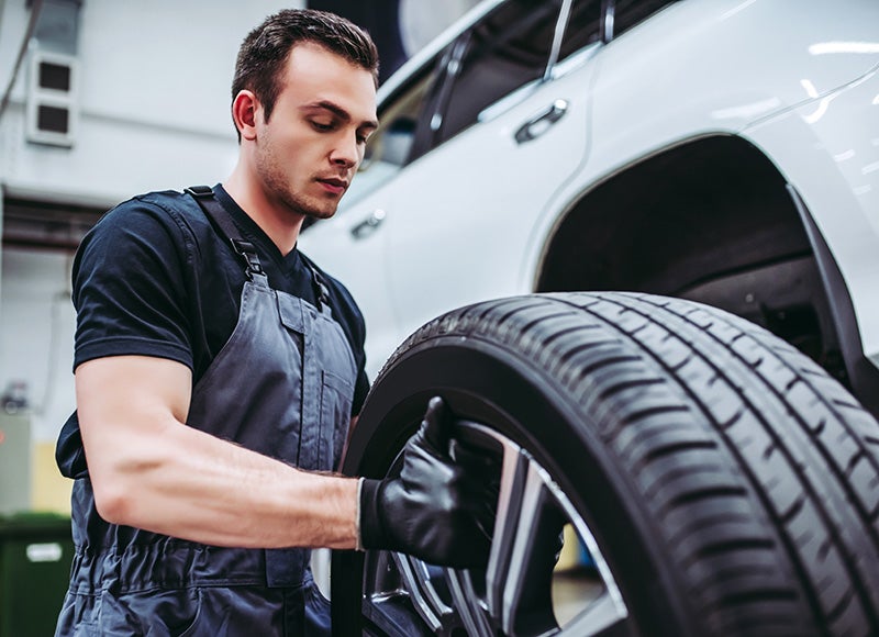 Service technician holding a new tire - Gandrud Chevrolet in Green Bay WI